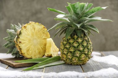 Ahşap tahta masada taze dilimlenmiş ve tüm ananas ile.