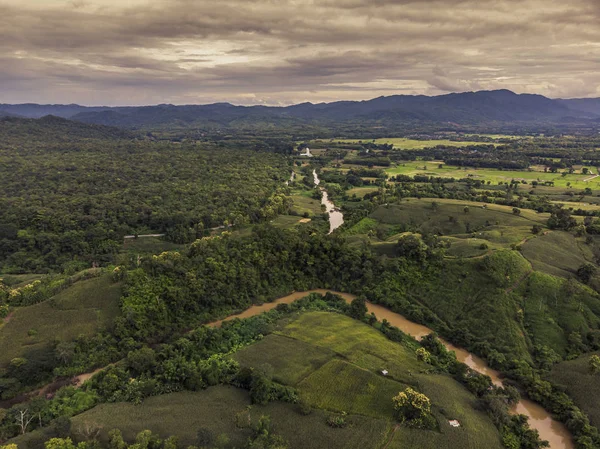 Top View of Rural Road, Path through green forest and countryside of Thailand. Top view. Aerial photo from drone.