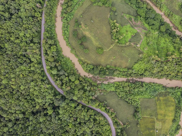 Top View of Rural Road, Path through green forest and countryside of Thailand. Top view. Aerial photo from drone.