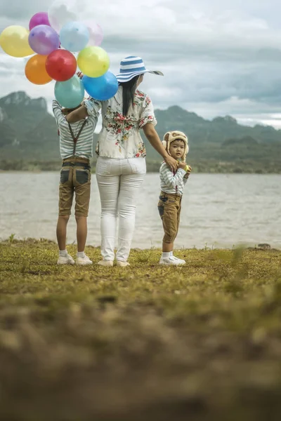ビーチのカラフルな風船を保持している幸せな家族 — ストック写真