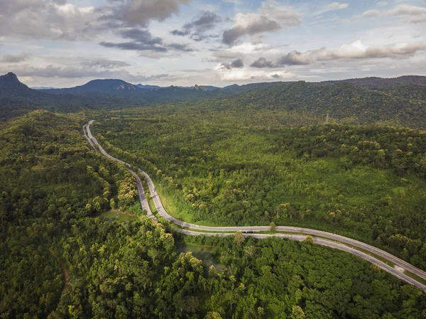 Top View of Rural Road, Path through green forest and countryside of Thailand. Top view. Aerial photo from drone.