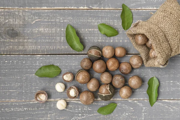 Nueces Macadamia Esparcidas Del Saco Sobre Fondo Madera — Foto de Stock