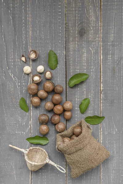 Nueces Macadamia Esparcidas Del Saco Sobre Fondo Madera — Foto de Stock