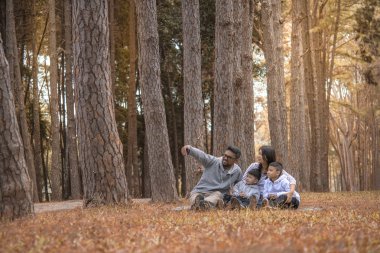 Doğada eğlenen çocuklu genç bir aile, baba, anne ve çocuklar.