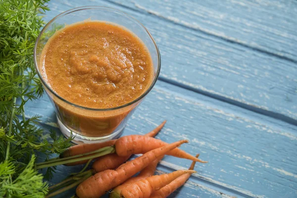 Rustik ahşap arka plan üzerinde cam taze havuç yüzlü.