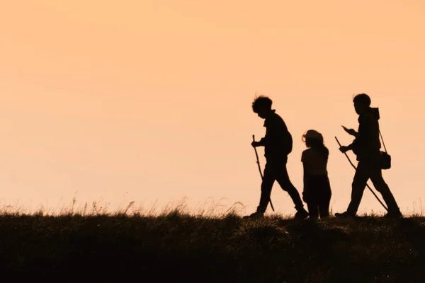 Silhouettes de randonneurs avec sacs à dos bénéficiant d'une vue coucher de soleil de t — Photo