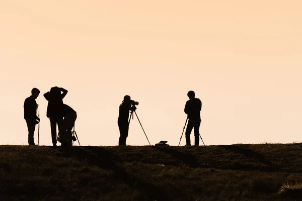 Silhouetten van wandelliefhebbers met rugzakken genieten van zonsondergang vanaf t — Stockfoto