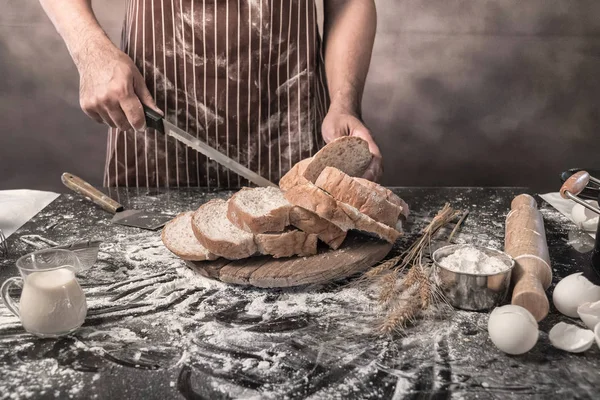 Man preparing buns at table in bakery