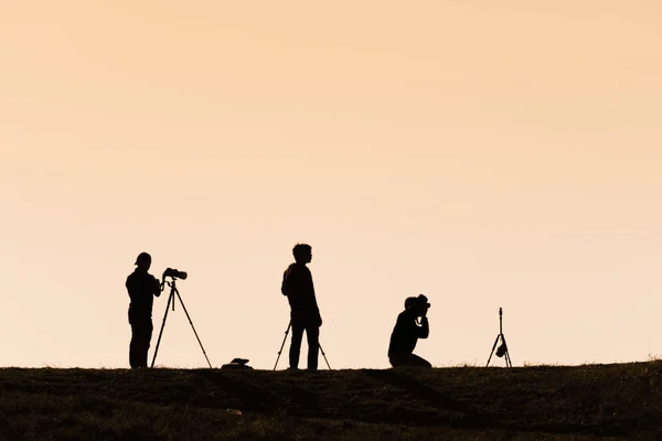 Siluetas de excursionistas con mochilas disfrutando de vista al atardecer desde t — Foto de Stock