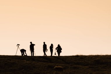 Sırt çantaları ile yürüyüşçüsiluetleri t gün batımı manzarasının keyfini çıkarın