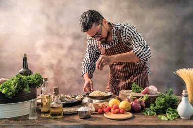 Yakışıklı sakallı cheef cook prepairing spagetti üzerinde bir mutfak, şef aşçılar yemek