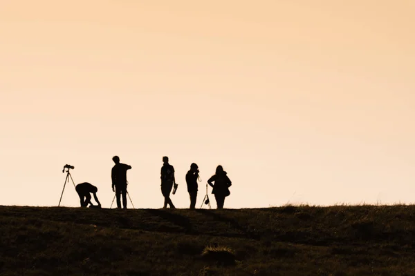 Siluetas de excursionistas con mochilas disfrutando de vista al atardecer desde t — Foto de Stock