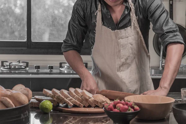 Man preparing buns at table in bakery