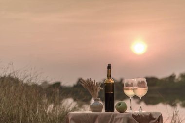 İki bardak ile gün batımında bir plajda yaz aylarında romantik bir akşam yemeği