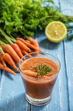 Rustik ahşap arka plan üzerinde cam taze havuç yüzlü.
