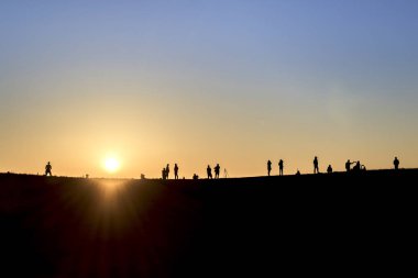 Sırt çantaları ile yürüyüşçüsiluetleri t gün batımı manzarasının keyfini çıkarın