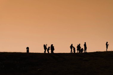 Sırt çantaları ile yürüyüşçüsiluetleri t gün batımı manzarasının keyfini çıkarın