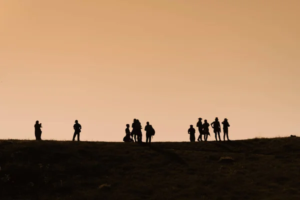 Siluetas de excursionistas con mochilas disfrutando de vista al atardecer desde t — Foto de Stock