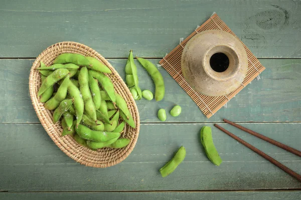 Grön japansk sojabönor i träskål på bord trä — Stockfoto