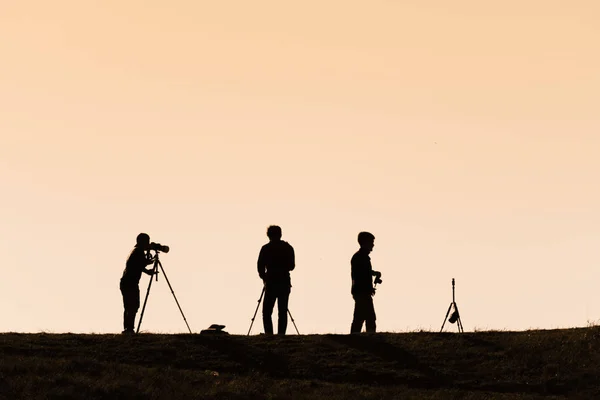 Silhouetten van wandelliefhebbers met rugzakken genieten van zonsondergang vanaf t — Stockfoto