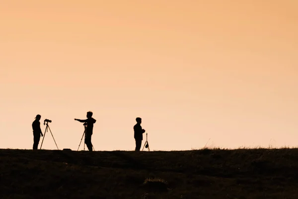 Silhouetten van wandelliefhebbers met rugzakken genieten van zonsondergang vanaf t — Stockfoto