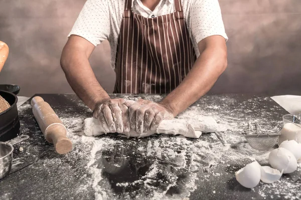 Homem preparando pães à mesa na padaria — Fotografia de Stock