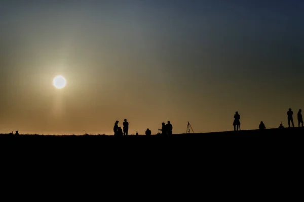Sırt çantaları ile yürüyüşçüsiluetleri t gün batımı manzarasının keyfini çıkarın — Stok fotoğraf