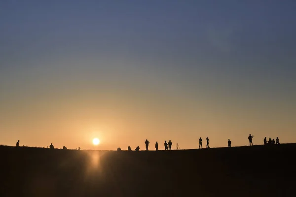 Silhouettes of hikers with backpacks enjoying sunset view from t — Stock Photo, Image