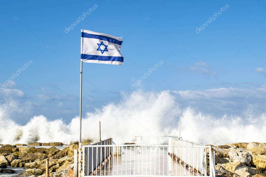 Flag of Israel on the promenade of Tel Aviv, the Israeli flag among the waves of the Mediterranean Sea, Independence Day