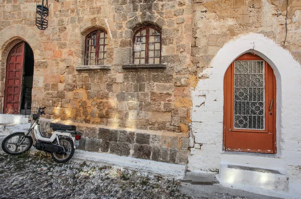 Черно-белый скутер возле средневековой каменной стены — стоковое фото