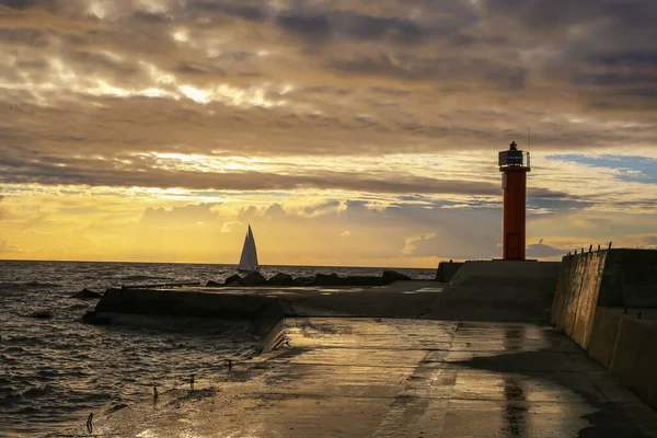 Colorful stormy sunset at the Rigas bay with Mangalsala light house