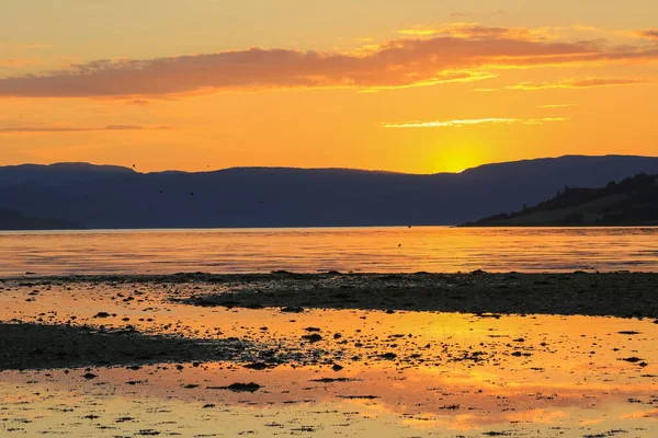 Trondheim fiyordunda gelgit, kumlu sahil manzarası Oeysand ve renkli yaz günbatımında Gaulosen doğa rezervi.