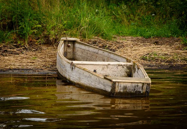 Orman gölün kıyısında yakınındaki eski ahşap balıkçı teknesi