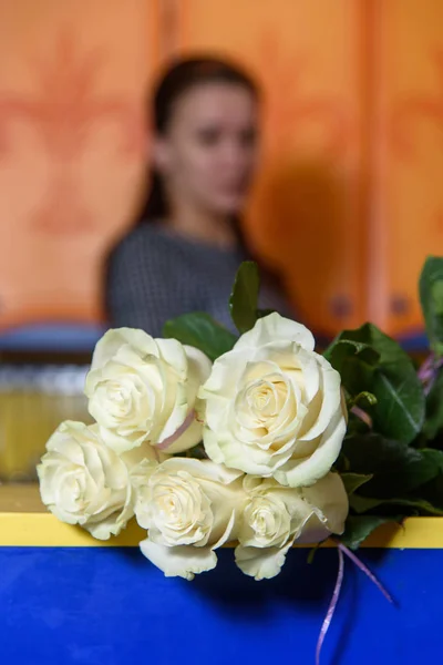 Bir buket çiçek masanın üzerinde. Masada beyaz güller.