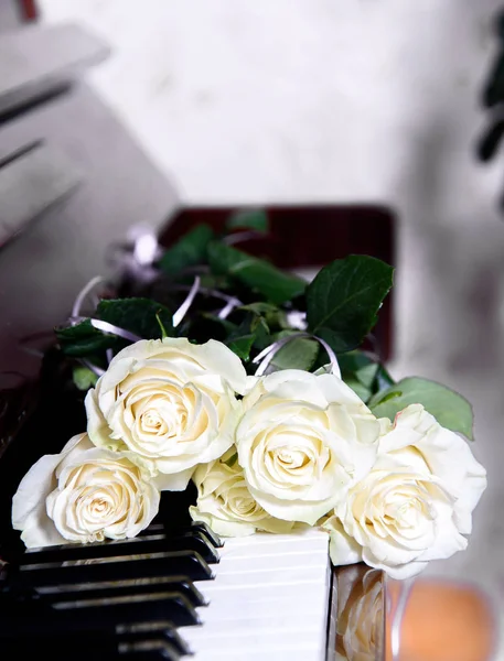 Bir buket çiçek piyano tuşlarını. Bir müzik aleti üzerinde beyaz gül buketi.