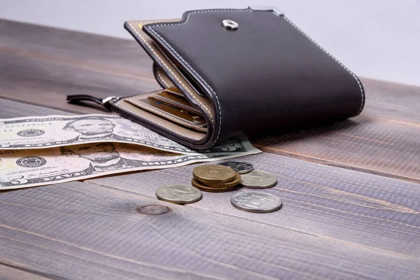 Banka kartları ve paralı erkek deri cüzdanı. Cüzdan ve para ahşap bir masada..