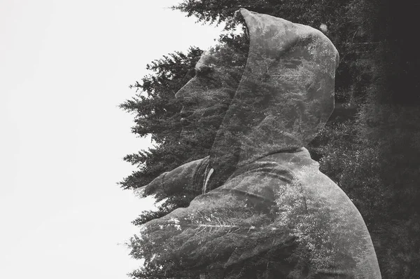 Düşünceli bir adamın portresi, arka plandaki ağaçlara karşı, çift pozlama..