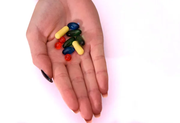 Pillole e capsule in una palma da donna. Medicina nei palmi delle mani. — Foto Stock