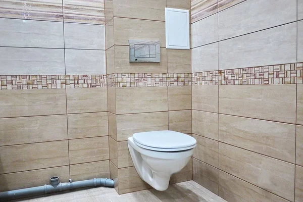 Toilet design with built-in toilet. Built-in toilet is made as an installation, all the elements, except for the toilet are hidden behind the tiles in the wall.