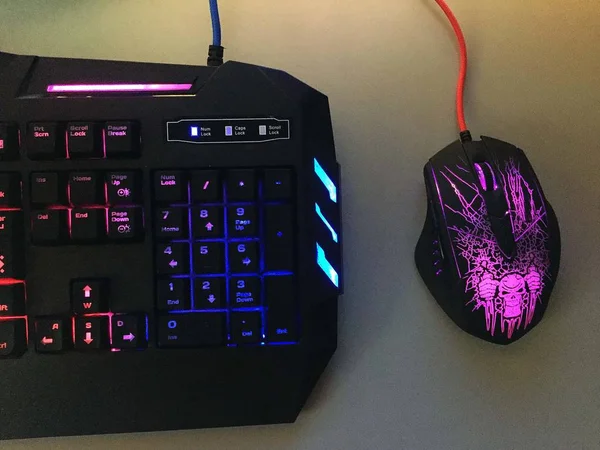 Gaming computer keyboard and mouse to control your personal computer and laptop and to play computer games. Beautiful RGB backlight gadget, close-up.