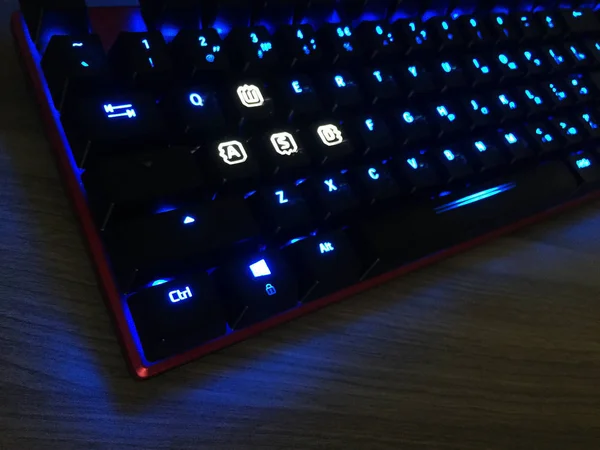 The gaming keyboard shines with multi-colored keys for the convenience of players. details and close-up.