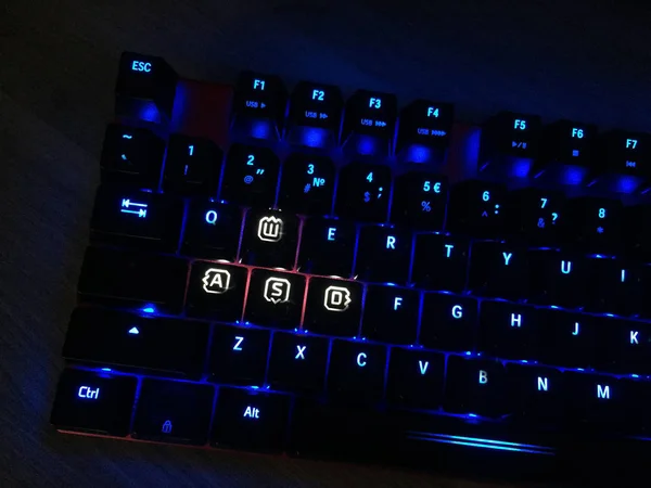 The gaming keyboard shines with multi-colored keys for the convenience of players. details and close-up.