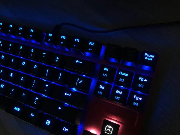 The gaming keyboard shines with multi-colored keys for the convenience of players. details and close-up.