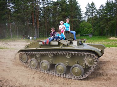 Çocuklar tankta gezin. İkinci Dünya Savaşı tankı 9 Mayıs tatilinde çocuklar ve yetişkinler rulo.