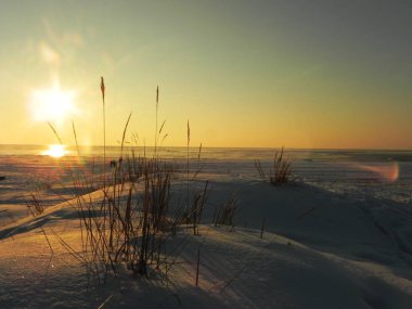 Buzun içinde denizde gün batımı. Güneş batarken buzlu denizi aydınlatır, buzlu ve Güneşli, detaylar ve yakın çekim.