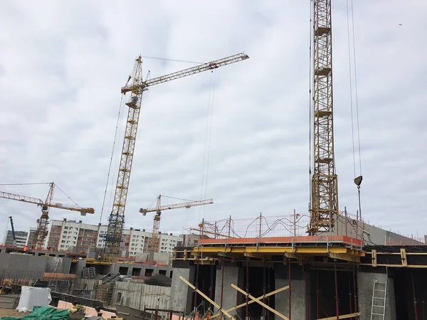 Stages of construction of a multi-storey building. The pouring of concrete and erection of panels floors. Details and close-up.