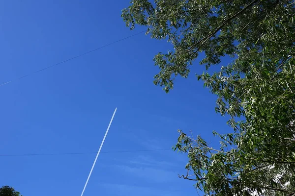 The track of the plane in the sky. The plane flies at high altitude.