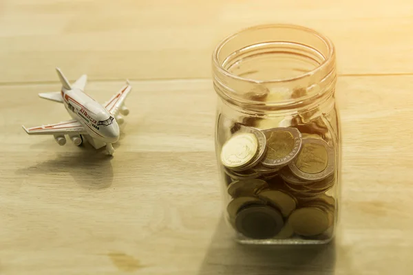 Travel budget concept. Travel money savings in a glass jar and put on wooden present budgets in holiday.