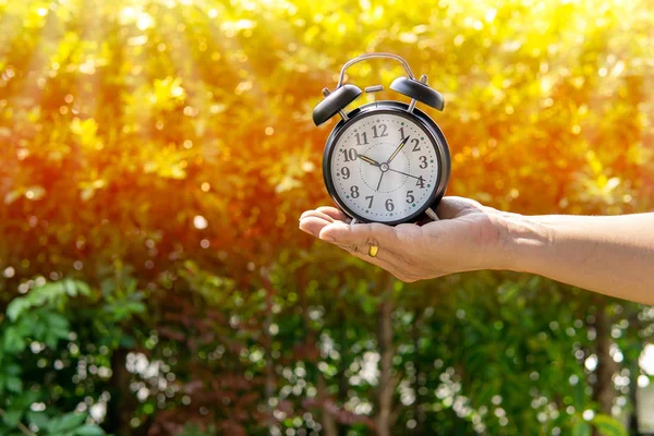Man Holding Alarm Clock Sunlight Park Background Show Concept Giving — Stock Photo, Image