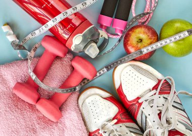 ruits, halter, su şişesi, halat, spor ayakkabı ve metre mavi bir arka plan üzerinde.